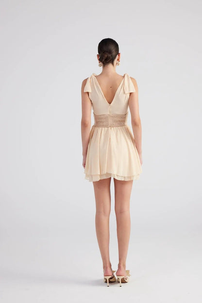 Fiona Beige Ruched Mini Dress with Pleated Skirt by Holly Lolly